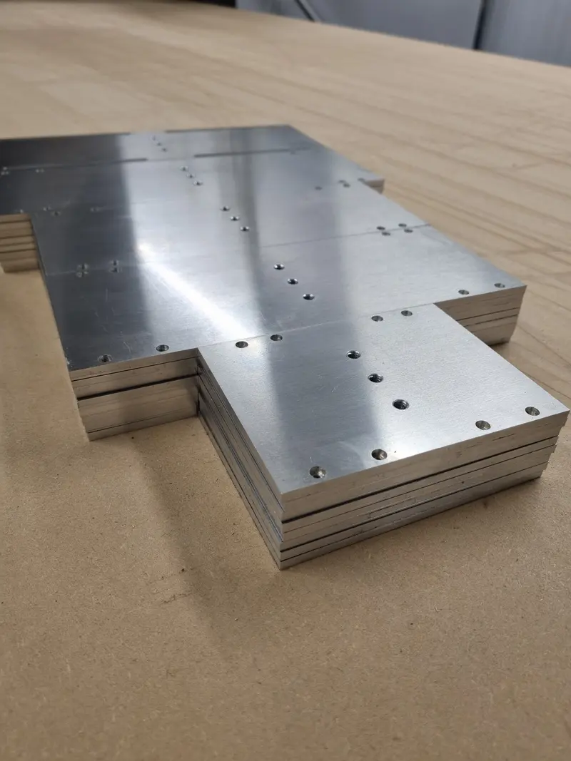 Stack of CNC-machined aluminium plates with drilled holes