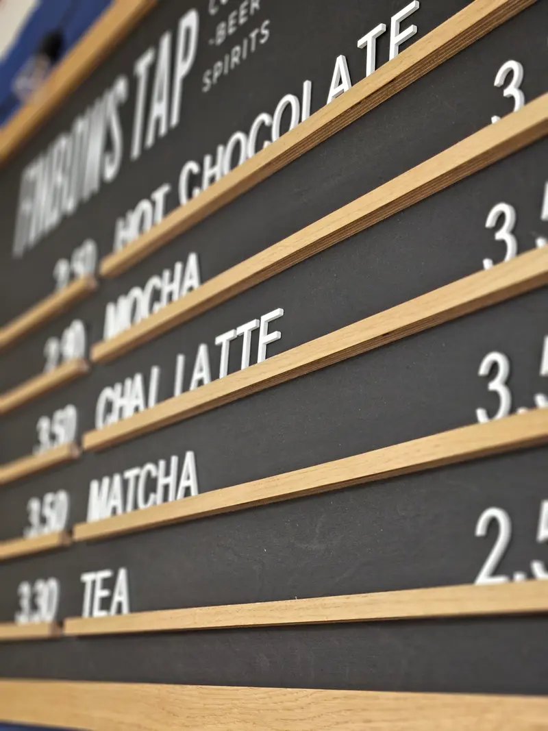 Black café menu board with timber slats and white lettering