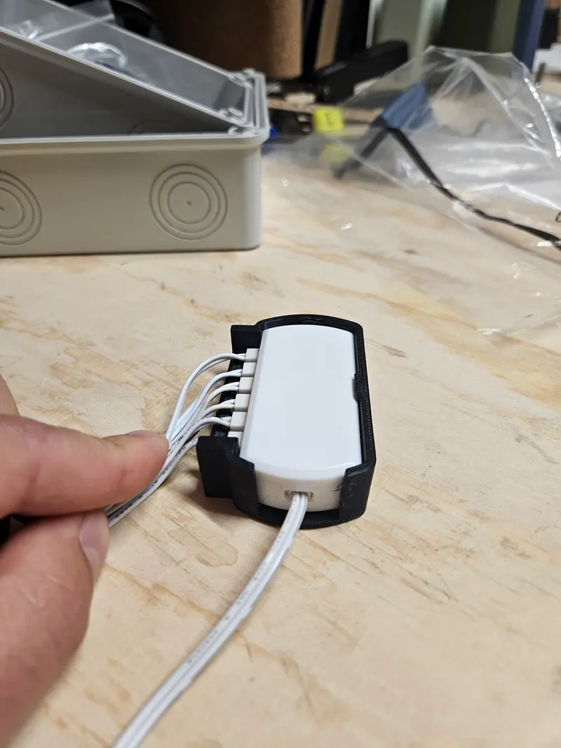 Hand holding a 3D printed electronics enclosure with cables