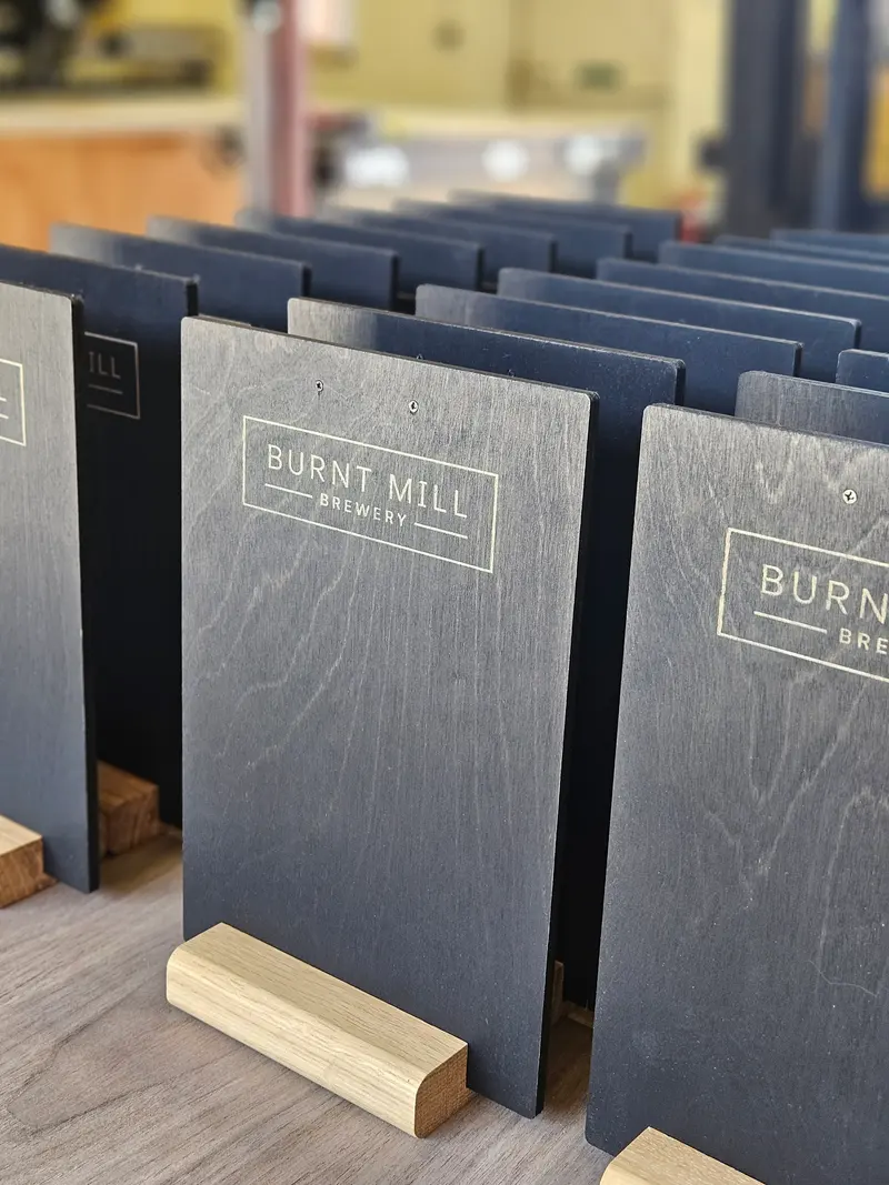 Row of engraved plywood menu boards on timber stands